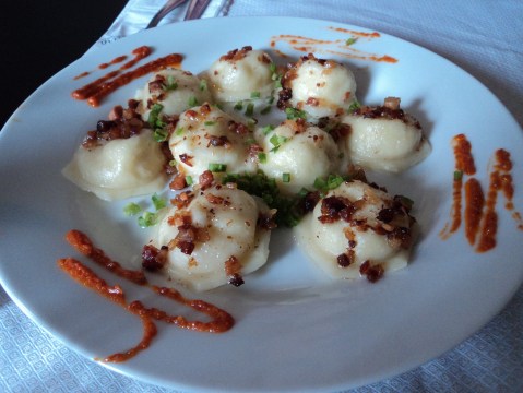 Pierogi com recheio de batata e queijo com molho de manteiga e bacon crocante