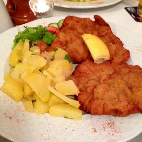 Prato-banquete com schnitzel de lombo de porco e salada de batatas cozidas.