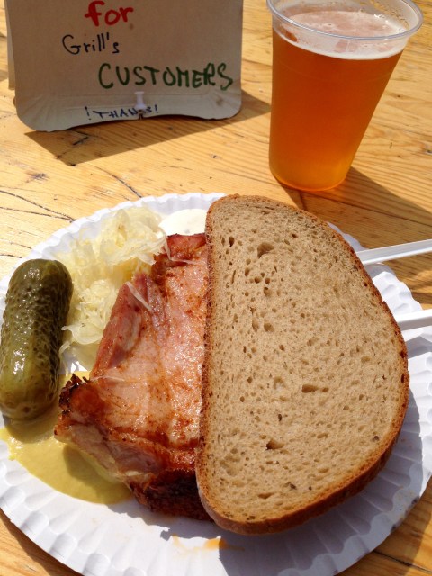 Almoço na feirinha medieval: lombo de porco na brasa, pão caseiro, chucrute e pepino em conserva. Cerveja artesanal para refrescar.